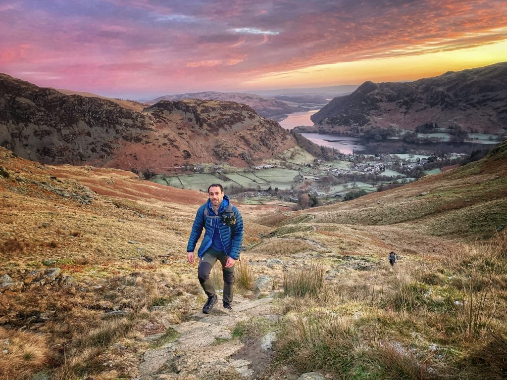 man walking up mountain track
